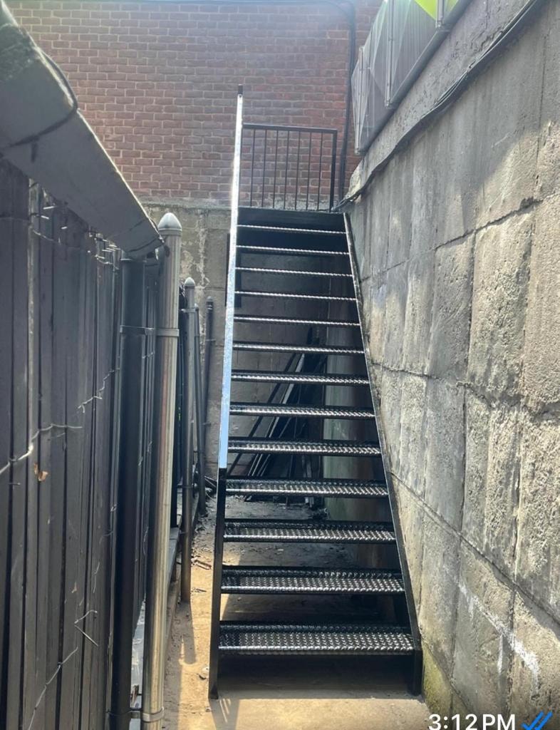 Metal staircase in narrow alley between buildings