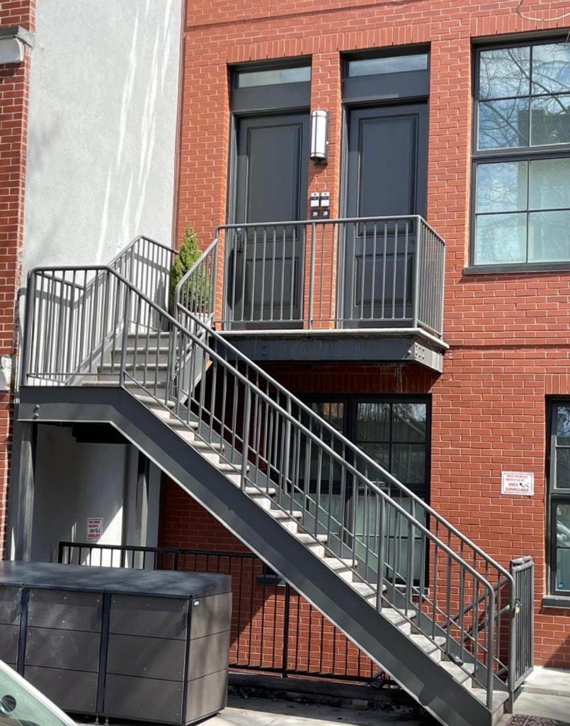 Gray metal staircase and balcony on red brick building