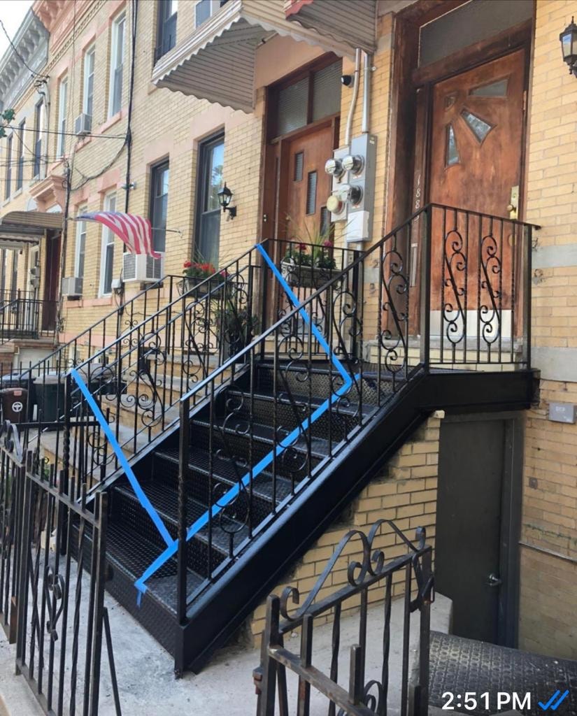 Brownstone building entrance with blue caution tape