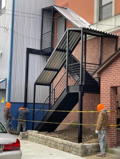 Black metal fire escape staircase on brick building