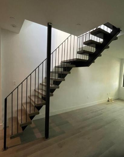 Modern interior floating staircase black metal railings wood treads