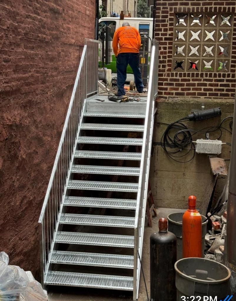 Galvanized steel staircase installation between brick buildings